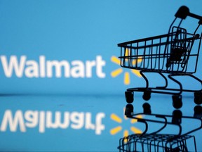 A shopping cart is seen in front of a Walmart logo in this photo illustration, July 24, 2022.