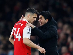 Arsenal's Spanish manager Mikel Arteta  speaks to Arsenal's Swiss midfielder Granit Xhaka during the English Premier League football match between Arsenal and Manchester City at the Emirates Stadium in London on February 15, 2023.