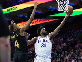 Philadelphia 76ers center Joel Embiid  drives for a score past Cleveland Cavaliers forward Evan Mobley during the fourth quarter at Wells Fargo Center.