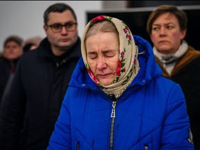 A woman reacts during a prayer service in St Andrew's Church in Bucha, near Kyiv on Feb. 24, 2023, on the first anniversary of the Russian invasion of Ukraine.
