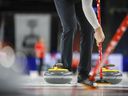 Curlers sweep a stone during a practice session at the Tim Hortons Brier in Lethbridge, Alta., Friday, March 4, 2022.