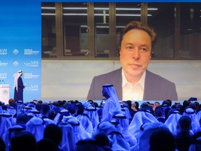UAE Minister of Cabinet Affairs Mohammad al-Gergawi (left on stage) speaks with Elon Musk attending the World Government Summit virtually in Dubai on Feb. 15, 2023.