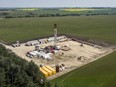 An oil drilling rig operates surrounded by canola and hay fields near Cremona, Alta., July 12, 2021. Canada's long-promised plan to transition its labour force to respond to climate change says a clean energy economy will not lead to massive unemployment.