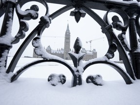 Snow covers a fence surrounding Parliament Hill in Ottawa, Jan. 20, 2023.