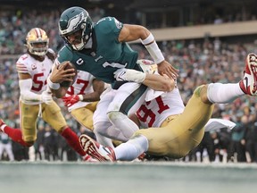 Philadelphia Eagles quarterback Jalen Hurts is tackled by San Francisco 49ers defensive end Nick Bosa during the second quarter in the NFC Championship game at Lincoln Financial Field.