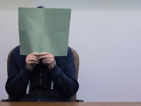 The defendant in the Wermelskirchen abuse complex holds a folder in front of his face in the courtroom in Cologne, Tuesday, Feb. 28, 2023.