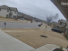 In this image made from video, a cloud of black smoke rises from where a Black Hawk helicopter crashed on Wednesday, Feb. 15, 2023, in Alabama. U.S. military officials say two people on board were killed.