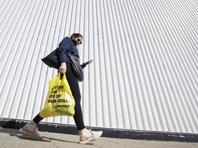 Inflation has eroded purchasing power for many Canadians, but the experience with rapidly rising prices has been far from uniform. A person leaves a Toronto supermarket with groceries, Oct. 5, 2022.