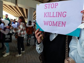 Iraqi women's rights activists lift placards during a rally near the Supreme Judicial Council in Baghdad on February 5, 2023, to protest the killing of Iraqi youtuber Tiba al-Ali by her father in Diwaniyah.