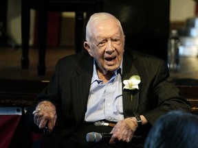 Former U.S. president Jimmy Carter reacts as his wife Rosalynn Carter speaks during a reception to celebrate their 75th wedding anniversary, July 10, 2021, in Plains, Ga.