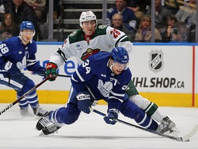Conor Dewar of the Minnesota Wild tries to contain Auston Matthews of the Toronto Maple Leafs at Scotiabank Arena on February 24, 2023 in Toronto.