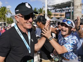 LIV Golf CEO Greg Norman, left, walks off the course after the final round of the LIV Golf Team Championship at Trump National Doral Golf Club, Sunday, Oct. 30, 2022, in Doral, Fla.