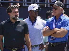 Yasir Al-Rumayyan, left, governor of Saudi Arabia's Public Investment Fund, Majed Al-Sorour, CEO of Golf Saudi, center, and Greg Norman, CEO of LIV Golf, watch at the first tee during the second round of the Bedminster Invitational LIV Golf tournament in Bedminster, N.J., on July 30, 2022.