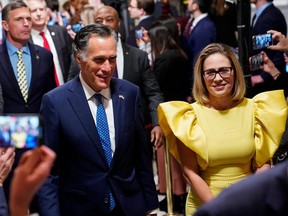 U.S. Senator Mitt Romney and U.S. Senator Kyrsten Sinema walk through Statuary Hall.