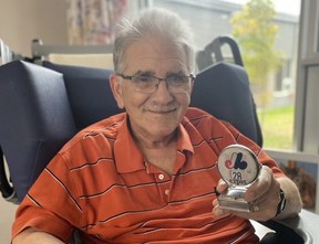 Steve Whitzman, now 72, shows off an Expos medallion from his extensive collection.