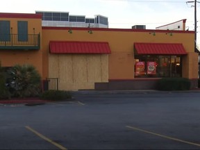 Popeyes location with boarded-up entrance after someone drove through it.
