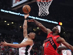 San Antonio Spurs' Keldon Johnson (left) drives to the basket as Raptors' Precious Achiuwa tries to defend during the first quarter at Scotiabank Arena on Wednesday, Feb. 8, 2023.