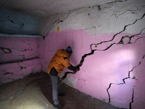 Rajendra Lal, shows multiple cracks in the walls of his house, in Joshimath, in India's Himalayan mountain state of Uttarakhand, Jan. 19, 2023.
