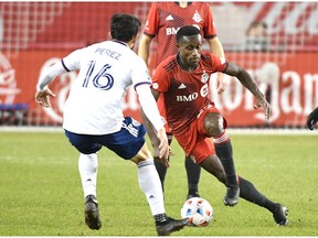 Toronto FC defender Richie Laryea dribbles the ball toward DC United forward Adrien Perez in the second half at BMO Field.
