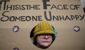 A teacher holds a placard while taking part in a protest organized NEU and other affiliated trade unions in Saint Peter’s square, in Manchester, on Feb. 1, 2023.