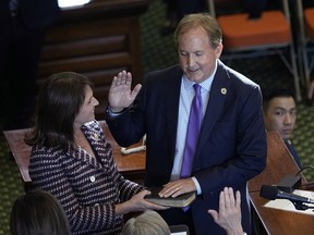 Texas AG settles with former aides who reported him to FBI Texas Attorney General Ken Paxton, right, stands with his wife Texas state Sen. Angela Paxton, left, as he is sworn in for a third term in Austin, Texas, Tuesday, Jan. 10, 2023.