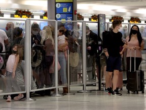 Record de 6 542 armes à feu interceptées à la sécurité des aéroports américains en 2022 2 Les voyageurs attendent dans une ligne de sécurité TSA alors qu'ils traversent l'aéroport international de Miami le 28 décembre 2021 à Miami, en Floride.