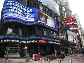 An electronic ticker displays news Wednesday, March 11, 2020, in New York's Times Square.