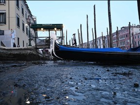 This photograph taken on Feb. 20, 2023, shows gondolas tied up in Venice Canal Grande, during a severe low tide in the lagoon city of Venice.