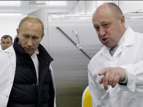 In this file photo taken on Sept. 20, 2010, businessman Yevgeny Prigozhin shows Russian Prime Minister Vladimir Putin his school lunch factory outside Saint Petersburg.