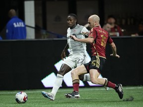 Atlanta United defender Andrew Gutman (15) tackles the ball against Toronto FC midfielder Richie Laryea.