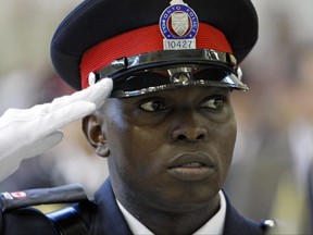 Newly minted cop Michael Juma salutes during his September 2009 graduation ceremony.