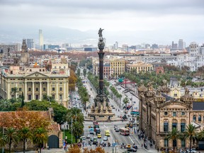 Aerial view over historical city center of Barcelona Spain with La Rambla main street, square Portal de la pau, Port Vell marina and Columbus Monument after sunset.