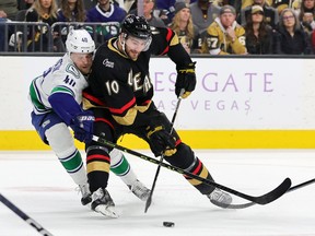 Nicolas Roy of the Vegas Golden Knights skates with the puck against Elias Pettersson of the Vancouver Canucks in the second period of their game at T-Mobile Arena on November 26, 2022 in Las Vegas, Nevada.