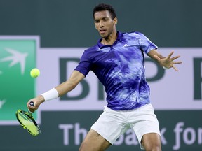 Felix Auger-Aliassime of Canada returns a shot to Tommy Paul during the BNP Paribas Open at the Indian Wells Tennis Garden on March 14, 2023 in Indian Wells, California.