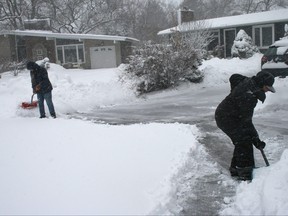 Two women shovel heavy snow in Oakville, Ont., on Friday, March 10, 2023.