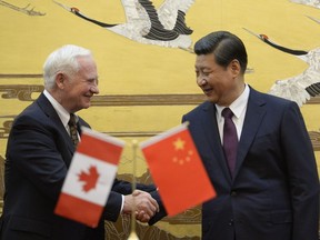 Canada's Governor General David Johnston (L) shakes hands with Chinese President Xi Jinping (R) after a signing ceremony at the Great Hall of the People in Beijing on October 18, 2013. Johnston's visit is aimed at boosting relations between Canada and China.