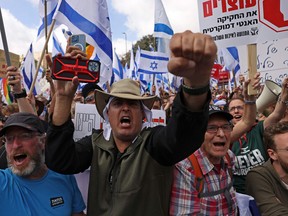 Protesters shout slogans outside Israel's parliament in Jerusalem amid ongoing demonstrations and calls for a general strike against the hard-right government's controversial push to overhaul the justice system, on March 27, 2023.