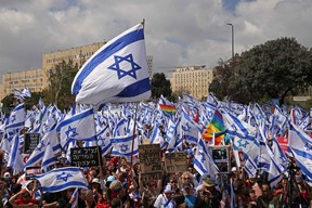 Protesters gather outside Israel’s parliament in Jerusalem amid ongoing demonstrations and calls for a general strike against the hard-right government’s controversial push to overhaul the justice system, on March 27, 2023. (Photo by HAZEM BADER / AFP)