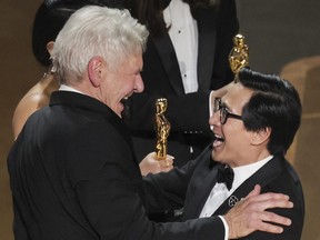 Ke Huy Quan receives the Oscar for Best Picture from Harrison Ford after "Everything Everywhere All at Once" won during the Oscars show at the 95th Academy Awards in Hollywood March 12, 2023.