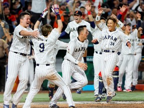 Mar 20, 2023; Miami, Florida, USA; Japan first baseman Kazuma Okamoto (center) reacts with teammates after winning the game against Mexico at LoanDepot Park.