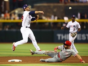 USA third baseman Nolan Arenado (left) throws to first base to complete the double play after forcing out sliding Canada base runner Edouard Julien in the sixth inning during the World Baseball Classic at Chase Field in Phoenix March 13, 2023.