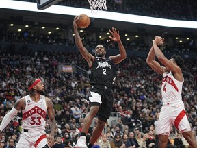 Dec 27, 2022; Toronto, Ontario, CAN; LA Clippers forward Kawhi Leonard (2) goes up to make a basket against Toronto Raptors guard Gary Trent Jr. (33) and forward Scottie Barnes (4) during the second half at Scotiabank Arena.