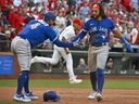 Blue Jays shortstop Bo Bichette (11) and right fielder George Springer (4) celebrate after they scored against the St. Louis Cardinals during the eighth inning at Busch Stadium. 