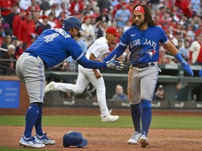 Blue Jays shortstop Bo Bichette (11) and right fielder George Springer (4) celebrate after they scored against the St. Louis Cardinals during the eighth inning at Busch Stadium.