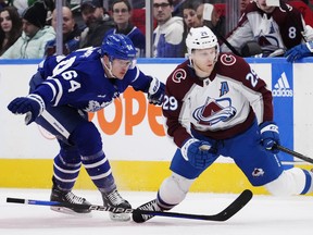 Maple Leafs' David Kampf (left) trips Colorado Avalanche's Nathan MacKinnon during the third period in in Toronto on Wednesday, March 15, 2023.