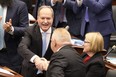 Ontario Finance Minister Peter Bethlenfalvy (left) shakes hands with Premier Doug Ford after tabling the provincial budget as Health Minister Sylvia Jones looks on at the legislature at Queen's Park in Toronto on Thursday, March 23, 2023.