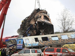A crane lifts parts of a destroyed carriage as rescuers operate on the site of a crash, where two trains collided, near the city of Larissa, Greece, March 2, 2023.