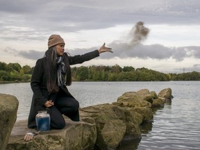Woman scattering the cremated ashes of a loved one into body of water.