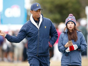Playing Captain Tiger Woods of the United States team and girlfriend Erica Herman look on during Saturday four-ball matches on day three of the 2019 Presidents Cup at Royal Melbourne Golf Course on December 14, 2019 in Melbourne, Australia.