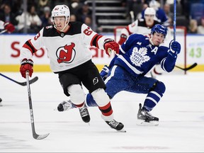 Toronto Maple Leafs right wing Mitchell Marner (16) and New Jersey Devils left wing Jesper Bratt (63) collide during second period NHL action, in Toronto, Thursday, Nov. 17, 2022.